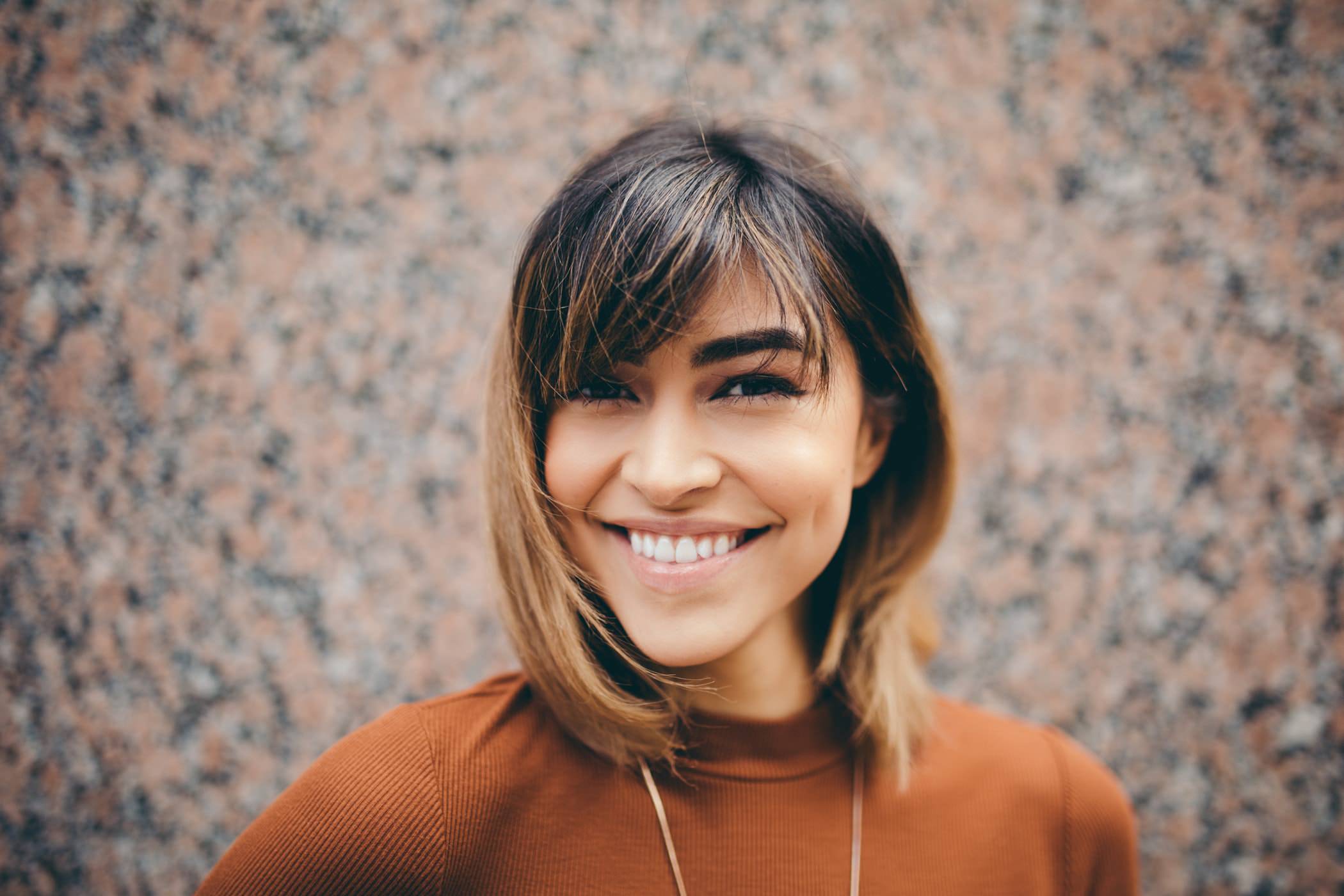 profile shot of young woman with hombre hair and orange sweater